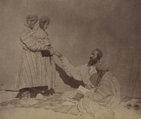 Zaravshanskii okrug. Vyslushivanie urokov (Zaravshan okrug. Listening to lessons; between 1865 and 1872): Photograph shows a Jewish man handing books to young boys. Sergei Mikhailovich Prokudin - Gorskii Collection (Library of Congress, Washington, D.C. 20540 USA).