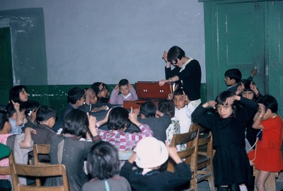 Louise Pascale teaching Afghan children the "Ali Baba" song which is about Ali Baba going to his garden where there are lots of animals, c. 1968, Afghanistan - National Museum of Afghanistan -  Photo by Jim Soules © Thierry Ollivier / Musée Guimet