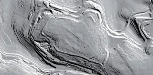 Titelberg (Luxemburg). Keltisches Oppidum (Stadtanlage) mit Ringwallanlage. Die Vegetationsdaten sind im DTM gefiltert. Sehr deutlich wird hier der unter Wald liegende Ringwall - also die verfallene ehemalige Stadtmauer - sicht­bar. Bemerkenswert sind auch die vielen tiefen Bodenrillen, die sich durch im Untergrund zusammenbrechende Stollenanlagen aus der Zeit des Eisenerzabbaus (19./20. Jh.) erklären. Der Berg „arbeitet“ massiv und schädigt dadurch natürlich auch die erhaltene archäologische Substanz. Das in Mehrjahresabständen zu wiederholende Laserscanning ermöglicht ein zuverlässiges zuverlässiges „Monitoring“ der enstehenden Veränderungen.